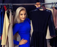 Fashion portrait of young blonde beautiful lady in clothing store photo