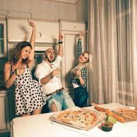 Group Of Friends Enjoying Evening Drinks and dancing at house party photo