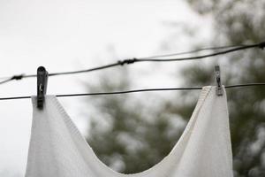 white waffle towel hanging on an iron wire pinned on the street photo