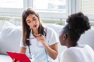 médico que trabaja en la oficina y escucha al paciente, ella está explicando sus síntomas, atención médica y concepto de asistencia médico serio con portapapeles y paciente en el hospital. foto