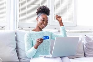 Young beautiful woman happy for finding shopping items for sale online. Beautiful girl using laptop computer for online shopping at home photo