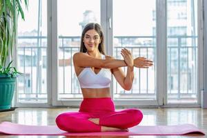 Beautiful woman stretching arms . Fitness female doing warmup workout. Fitness woman doing stretch exercise stretching her arms - tricep and shoulders stretch . Fit girl living an active lifestyle. photo