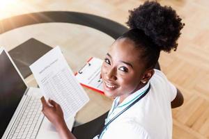 Healthcare costs and fees concept. Top view of smart doctor calculating medical costs in modern hospital. Doctor completing a Medical Claim Form ,Stethoscope photo