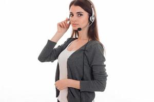 young pretty brunette business woman with headphones and microphone looking at the camera isolated on white background photo