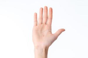 mano femenina levantada con un ladoshkoj adelante aislado sobre fondo blanco foto