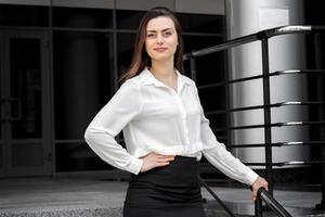 young business woman stand with hands on her hip and looking away photo