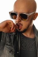 vertical portrait of sexual young macho man with hand at his mouth in sunglasses photo