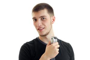 charming portrait of a young smiling guy with shaving machine in hand photo