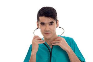 a young doctor with stethoscope seriously looking at camera photo