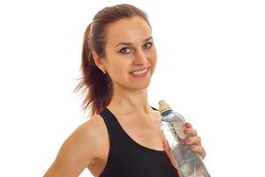 horizontal portrait of charming young girl sports which keeps the water bottle and smiling photo