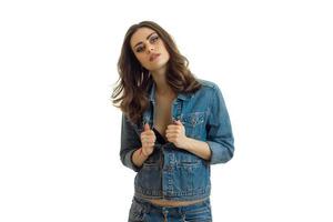 charming brunette in jeans jacket posing in Studio photo
