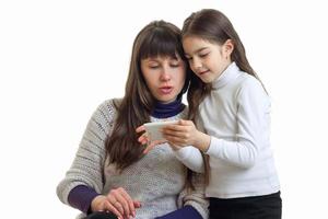 madre con su hija usando tableta móvil foto