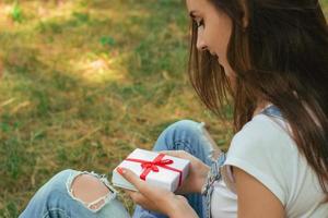 Portrait of a young lady that holds gift box photo