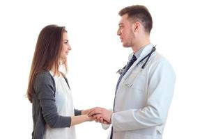 una joven sonriente se para frente al médico y le mantuvo las manos foto