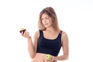 young girl in black top keeps Apple in hand isolated on white background photo