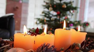 vier brandend kaarsen Aan Kerstmis krans schijnend helder met romantisch humeur Bij heilig vooravond en Kerstmis vakantie vooraan van een feestelijk versierd Kerstmis boom net zo traditioneel christen symbool voor komst