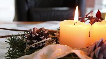quatro velas acesas na guirlanda de natal brilhando com humor romântico na véspera santa e feriados de natal na frente de uma árvore de natal festiva decorada como símbolo cristão tradicional para o advento video