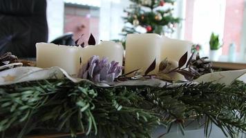 velas de natal são acesas na guirlanda de natal brilhando com clima romântico na véspera santa e feriados de natal na frente da árvore de natal festiva como símbolo cristão tradicional para o advento video