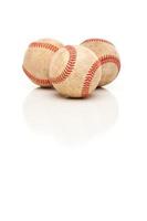 tres pelotas de béisbol aisladas en blanco reflectante foto