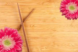 Gerber Daisy and Chopsticks on a Bamboo Background photo
