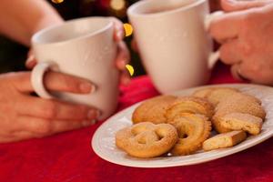 Man and Woman Sharing Hot Chocolate and Cookies photo