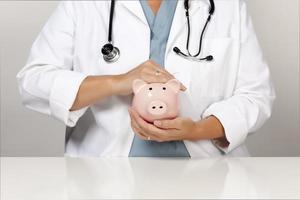 Doctor with Stethoscope Holding Piggy Bank Abstract photo