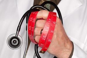 Doctor with Stethoscope Holding Measuring Tape photo