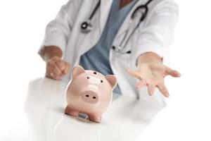 Demanding Doctor Reaches Palm Out Behind Piggy Bank photo