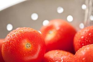 Fresh, Vibrant Roma Tomatoes in Colander with Water Drops photo