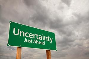 Uncertainty Green Road Sign Over Storm Clouds photo