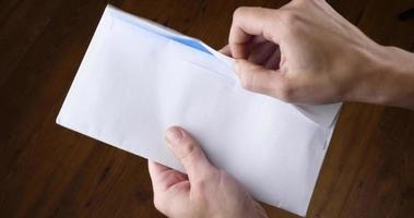 mão abre um envelope branco com um espaço em branco vazio video