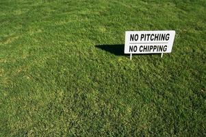 No Pitching or Chipping Sign on Lush Green Grass photo