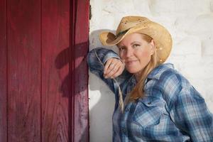 Beautiful Cowgirl Against Old Wall and Red Door photo