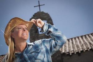 Beautiful Cowgirl Portrait with Old Church Behind photo