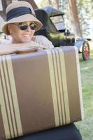 1920s Dressed Girl With Suitcase Near Vintage Car photo