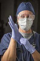 doctora o enfermera preocupada poniéndose ropa protectora facial foto