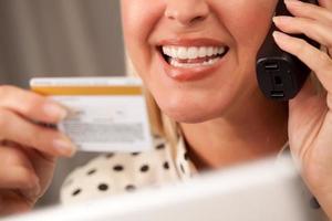Beautiful Woman on Phone Holding Credit Card photo