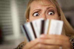 mujer molesta mirando sus muchas tarjetas de crédito foto