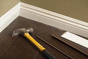Hammer, Laminate Flooring and New Baseboard Molding photo