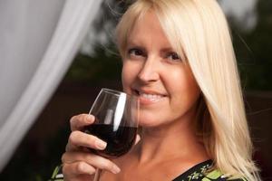 hermosa rubia disfrutando del vino foto