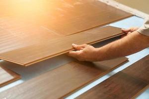 Man Installing New Laminate Wood Flooring photo