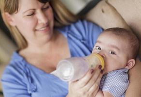 Happy Mother Bottle Feeding Her Son photo