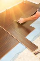 Man Installing New Laminate Wood Flooring photo