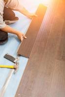 Man Installing New Laminate Wood Flooring photo