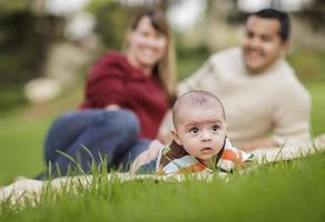 Happy Mixed Race Baby Boy and Parents Playing in Park photo