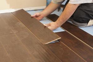 Man Installing New Laminate Wood Flooring photo