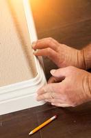 Contractor Installing New Baseboard with Bull Nose Corners and New Laminate Flooring photo