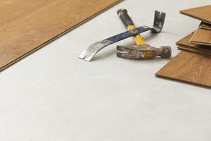 martillo y barra de palanca con suelo laminado abstracto foto