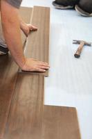 Man Installing New Laminate Wood Flooring photo