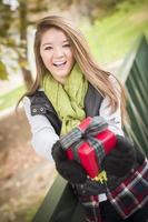 Pretty Woman with Wrapped Gift with Bow Outside photo